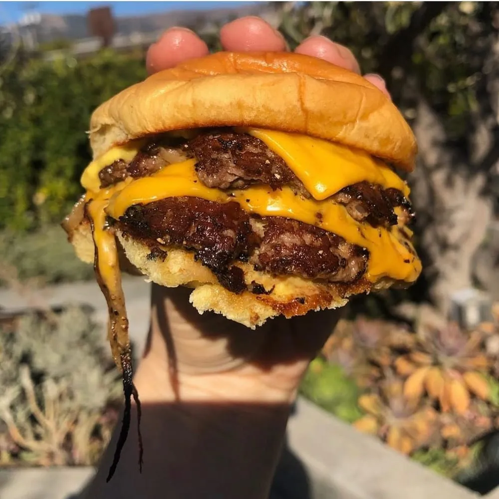 Third Window Brewing smashburger close-up with crispy wagyu patty edges, cheese, pickles, and sauce