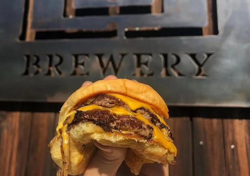 Third Window Brewing smashburger on a tray with fries and beer garden table setting