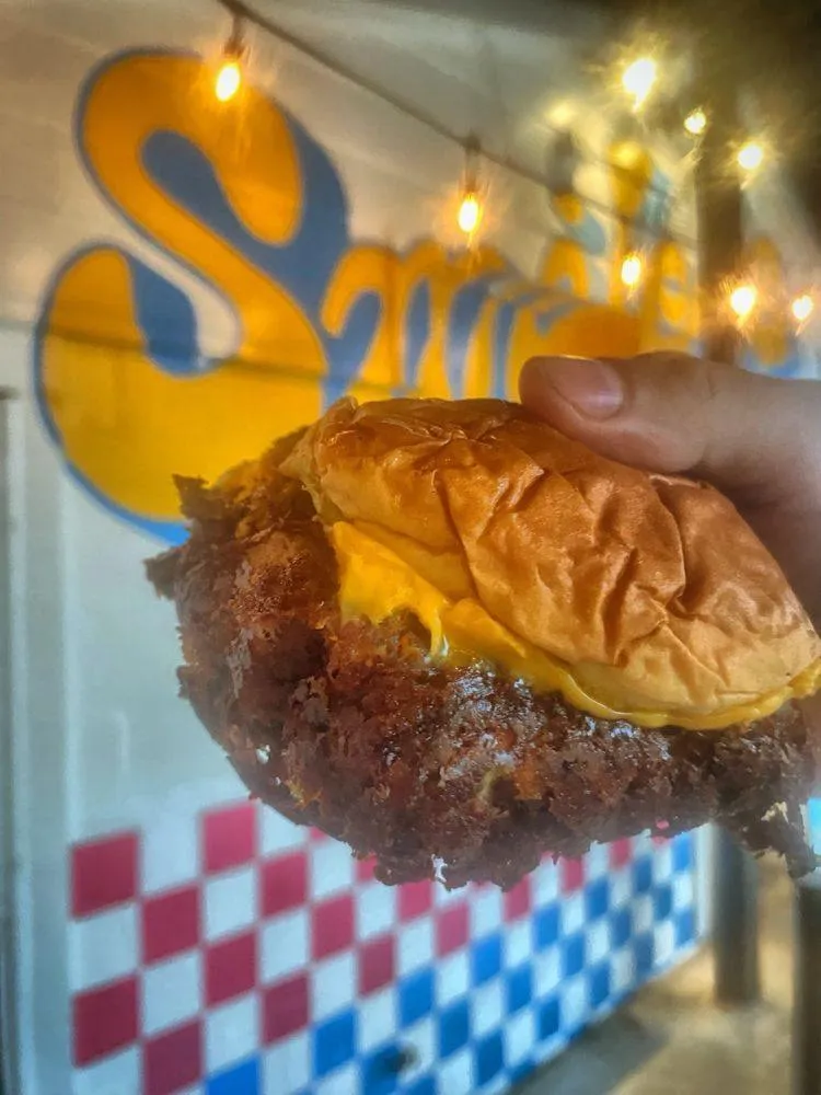 Smiley's Burger Club walk-up window with bright yellow signage in downtown Decatur