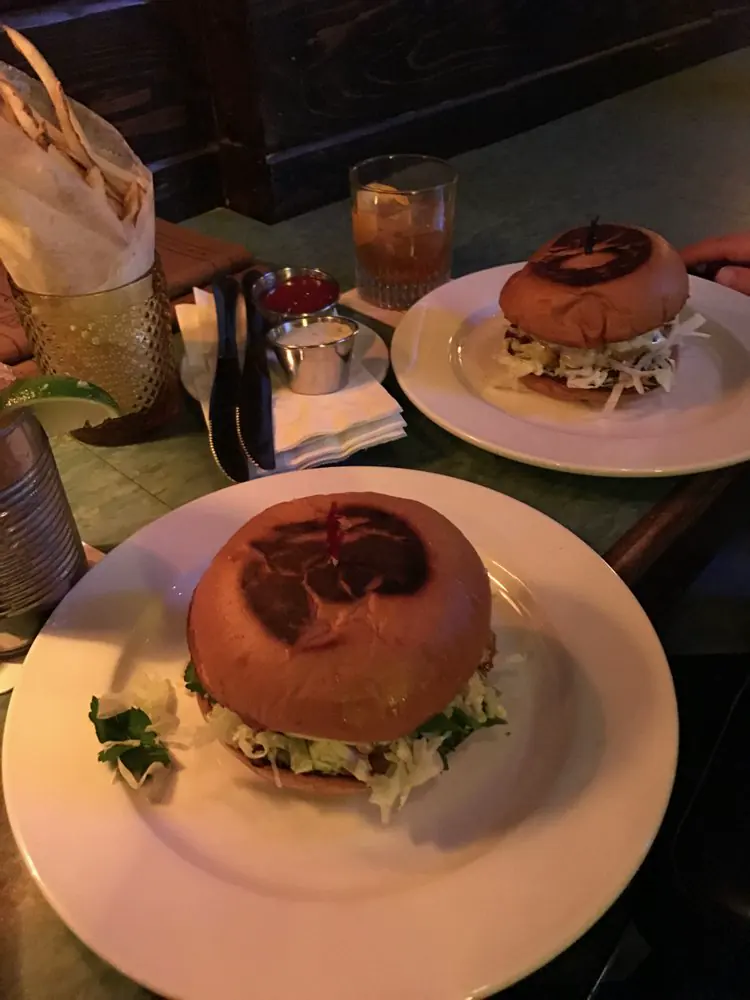Smashburger served in brown paper bag with foil wrapping, casual dive bar presentation
