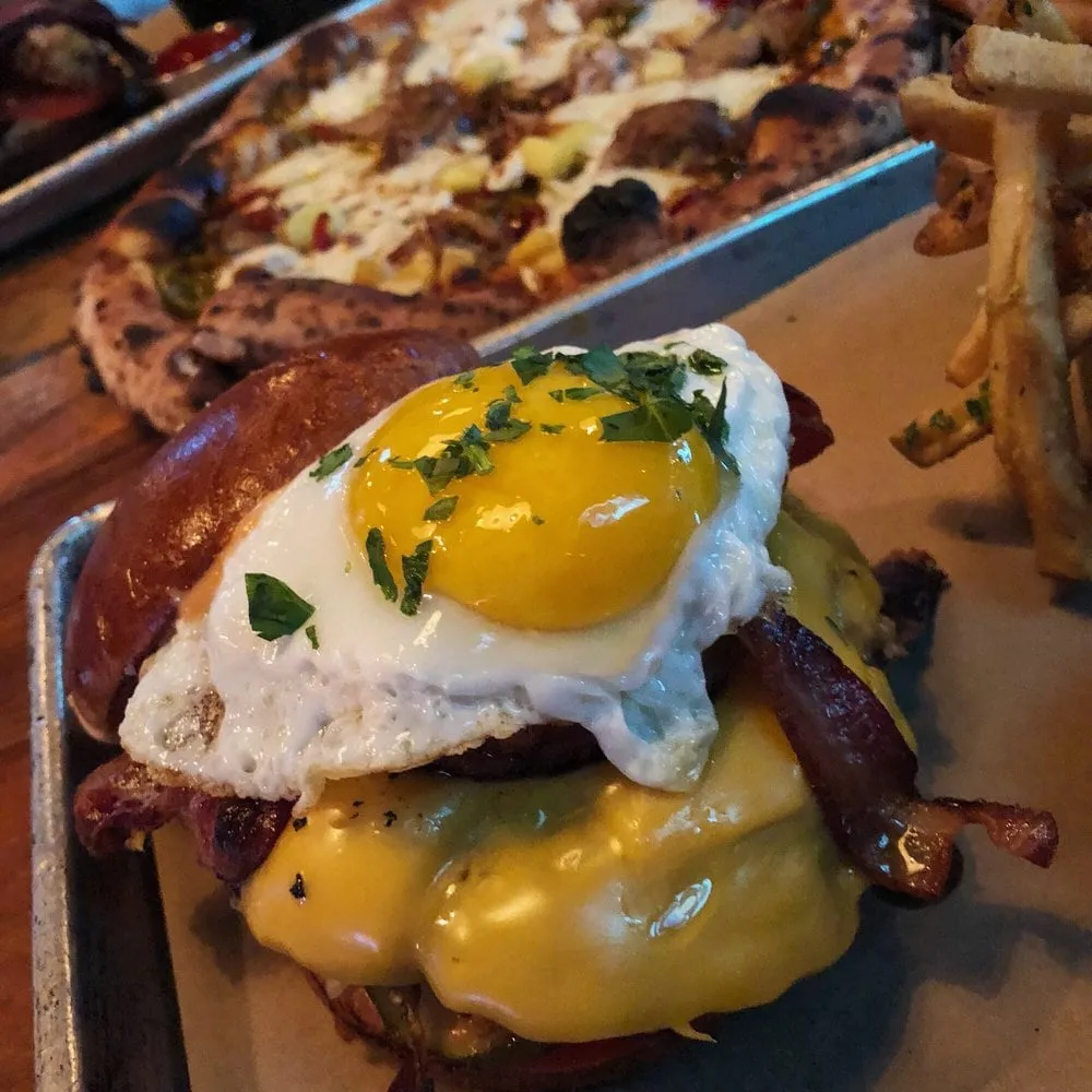 Parlor Pizza Bar cheeseburger topped with bacon and a fried egg
