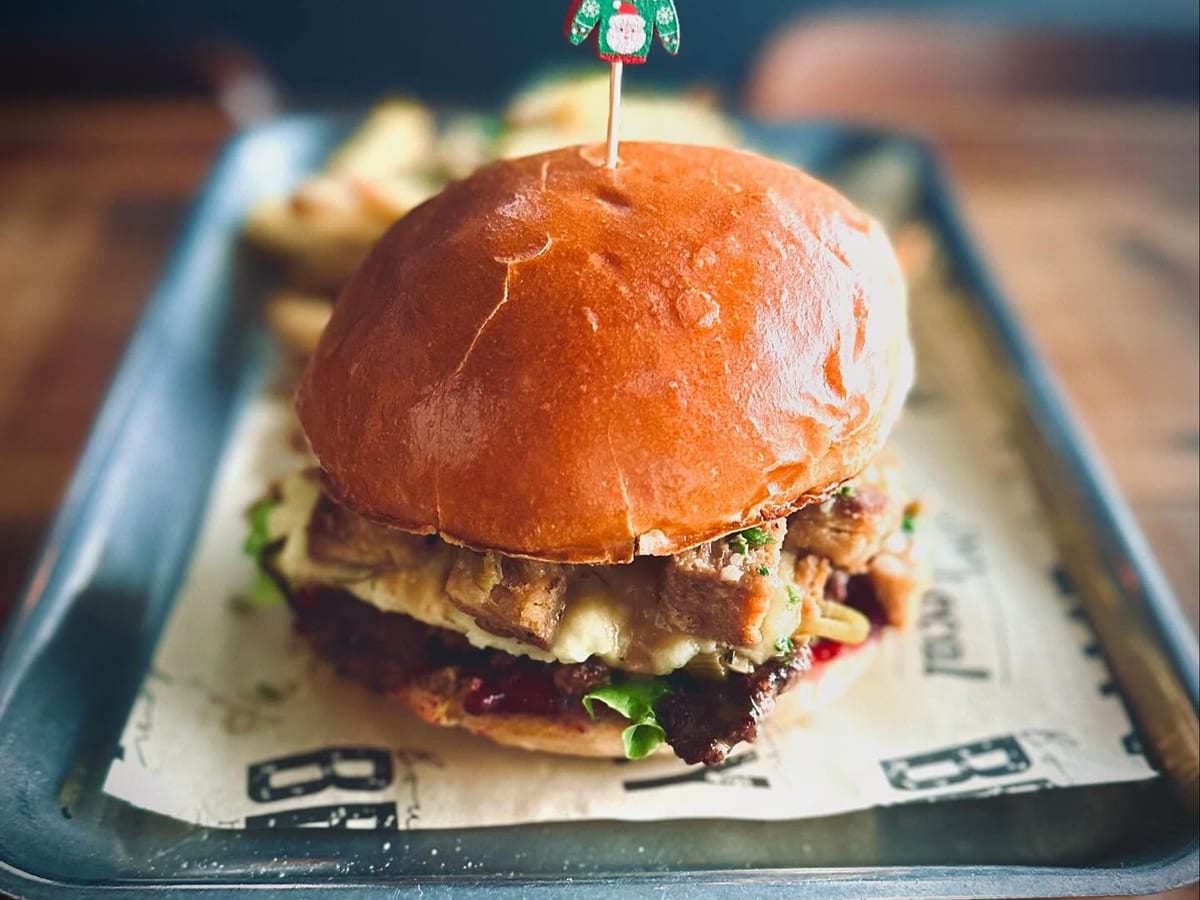 The Burger Local interior - industrial style with natural wood tones, vintage video game room