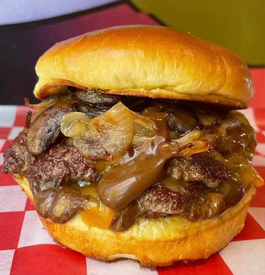 Close-up of Shaolin Burger with caramelized onions and black garlic aioli