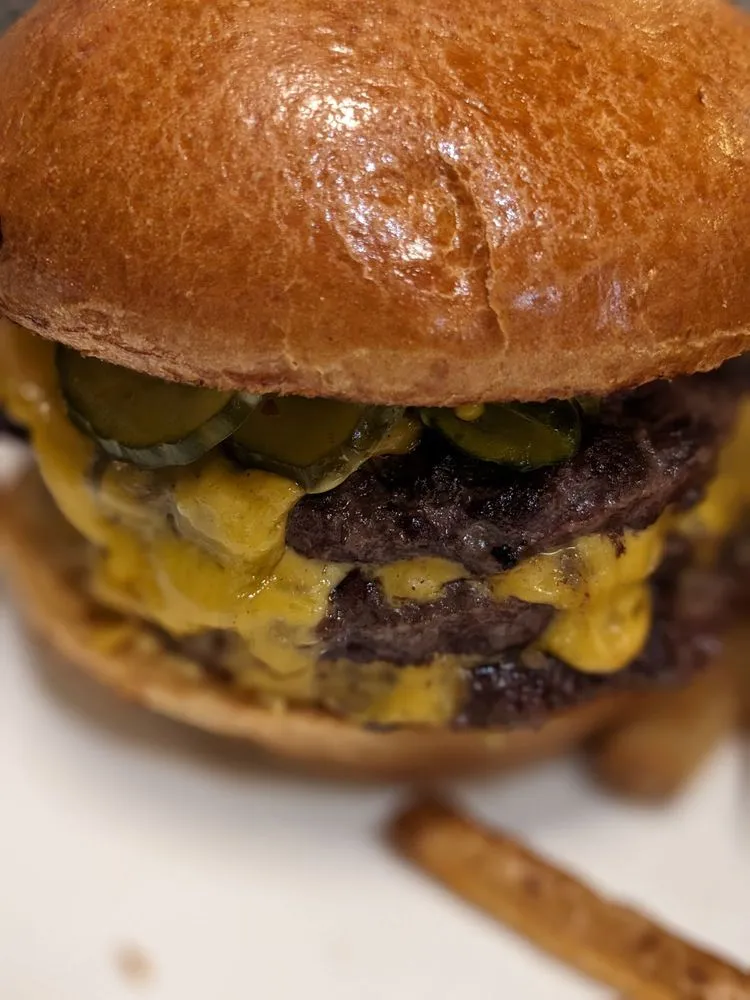 Close view of the Pullman Burger with melted American cheese and house pickles