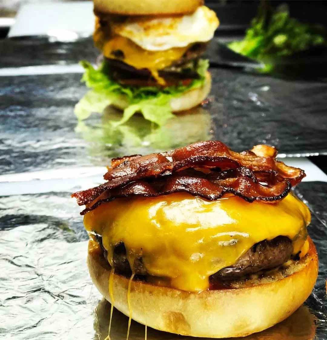 Dan & Day's bacon cheeseburger with melted cheddar on the griddle