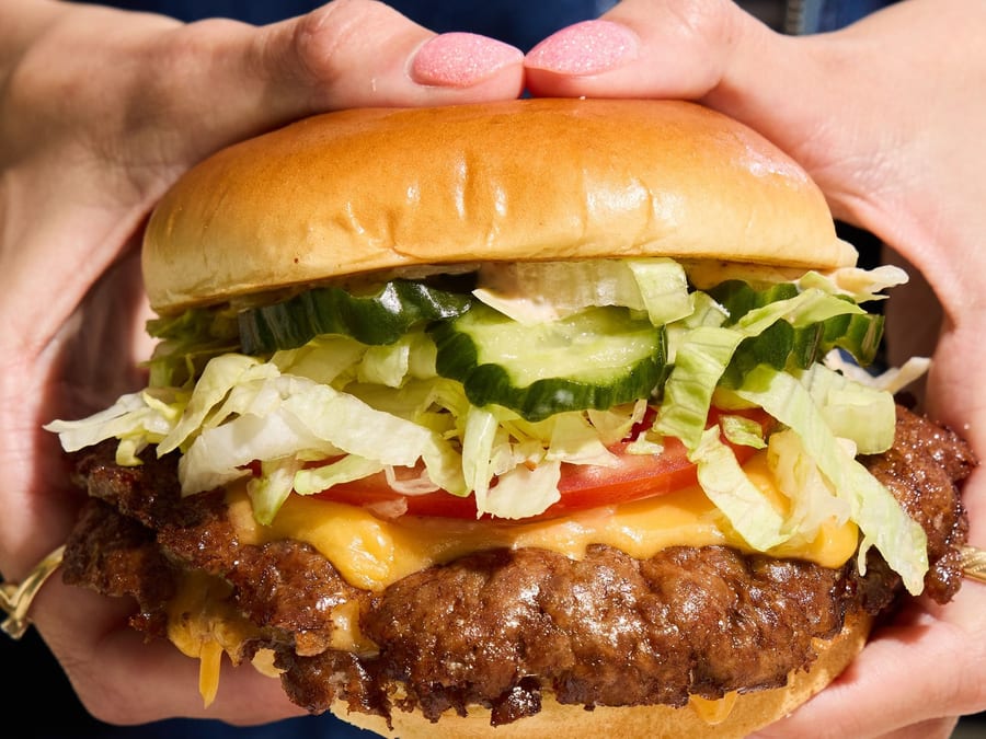 The Royale double smash burger at Harriet's Hamburgers — two smash patties with yellow American cheese, pickles, lettuce, tomato, and Good Good Sauce on French milk bread bun