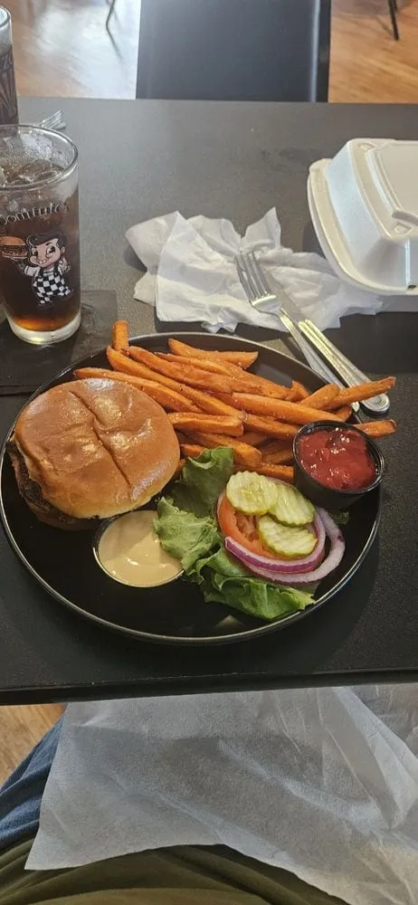 Dominic's Bar & Grill burger plate with sweet potato fries and fresh toppings