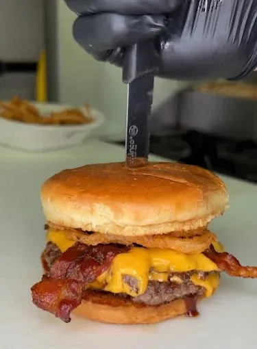 Dominic's Bar & Grill bacon cheeseburger pinned through the bun