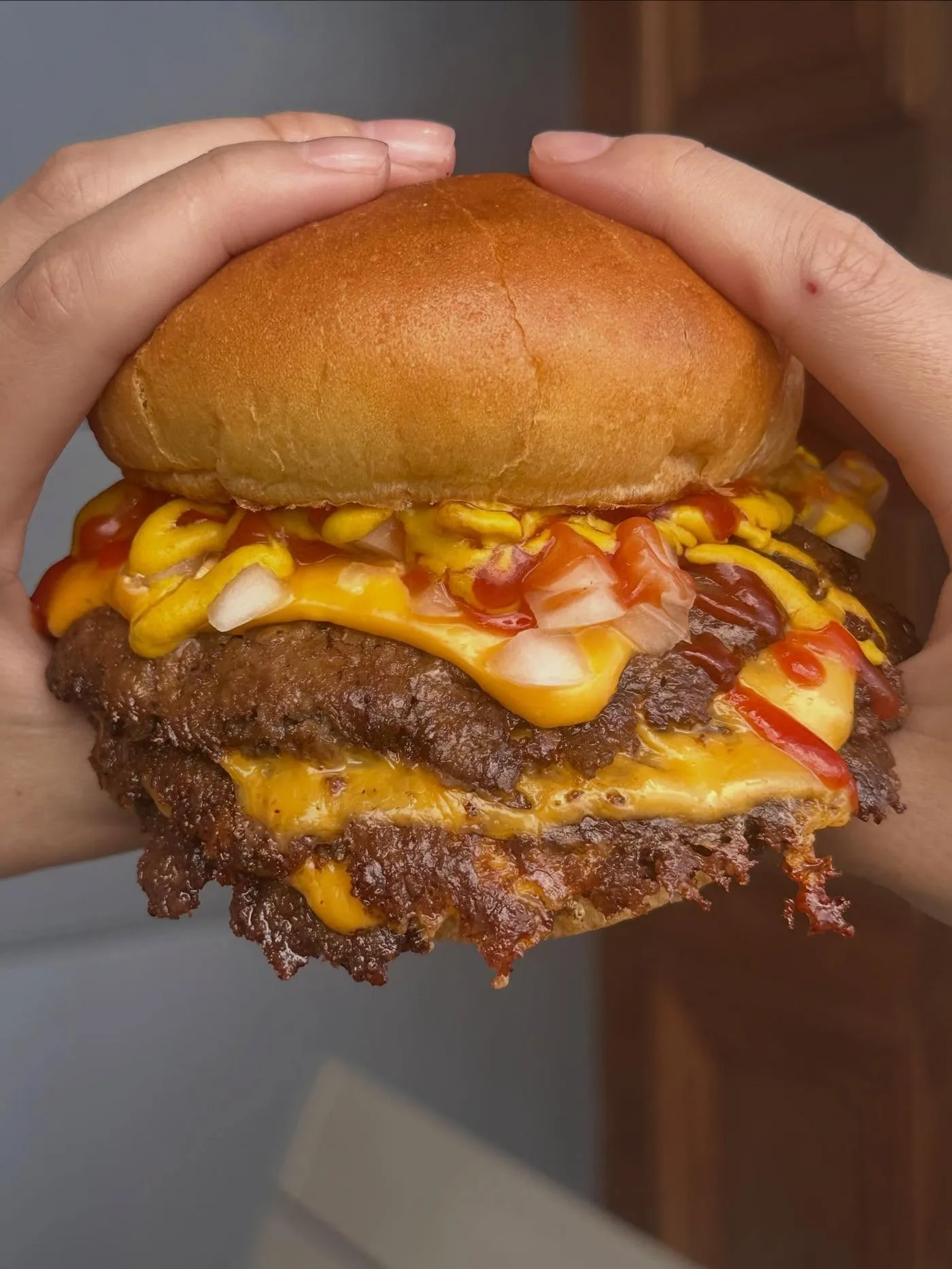 Oversized Burger Revolution double smashburger held in two hands