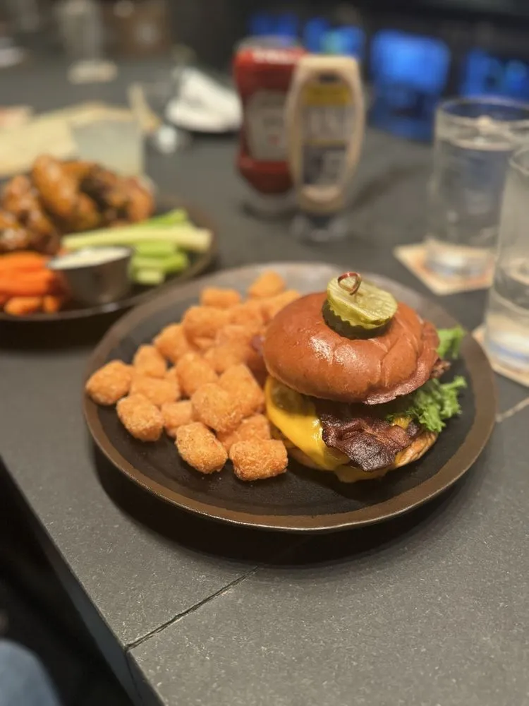Barlines smashburger with American cheese, bacon, lettuce, and tater tots