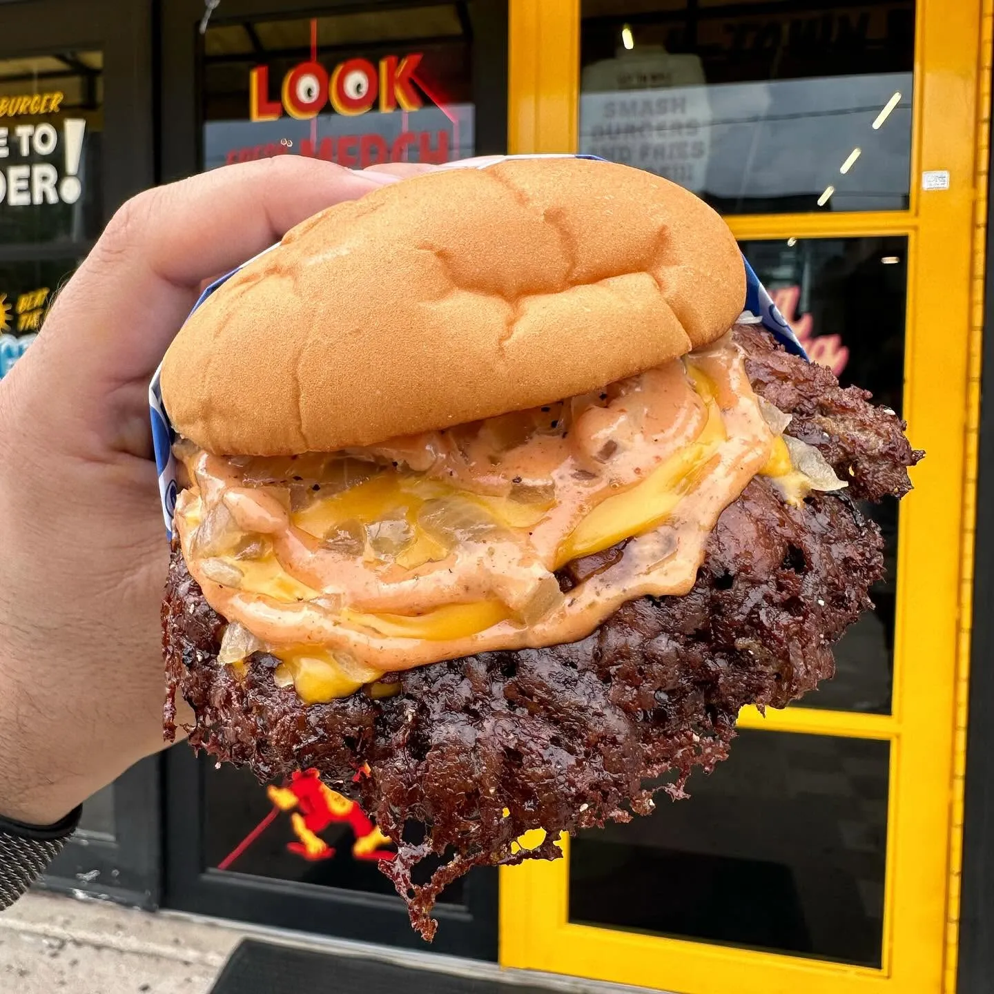 Burger Bodega double smashburger held outside the Houston restaurant